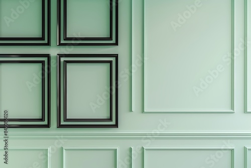 A chic office with a mint green wall, showcasing four empty black frames in a square pattern.