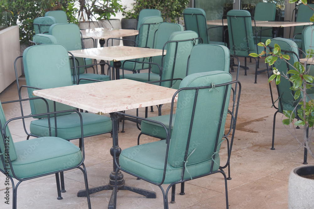 The restaurant has tables and chairs with green cushions for comfort The restaurant has tables and chairs with green cushions for comfort