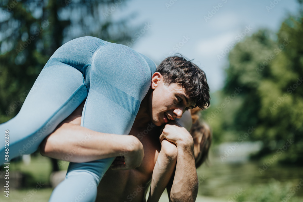 Muscular man working out in an open outdoor setting while carrying his friend on his shoulder, showcasing strength and fitness.