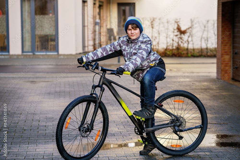 Handsome preteen boy going to school on bike. Teenager ride bicycle. Safe way to high school. Happy child boy with backpack on bike. Healthy outdoor activity for young student. Handsome preteen boy going to school on bike. Teenager ride bicycle. Safe way to high school. Happy child boy with backpack on bike. Healthy outdoor activity for young student.