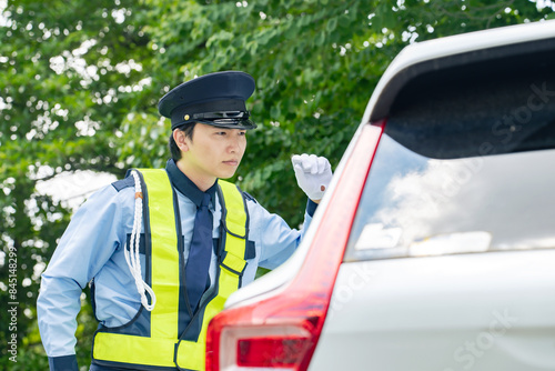 不審な自動車をチェックする警備員 photo