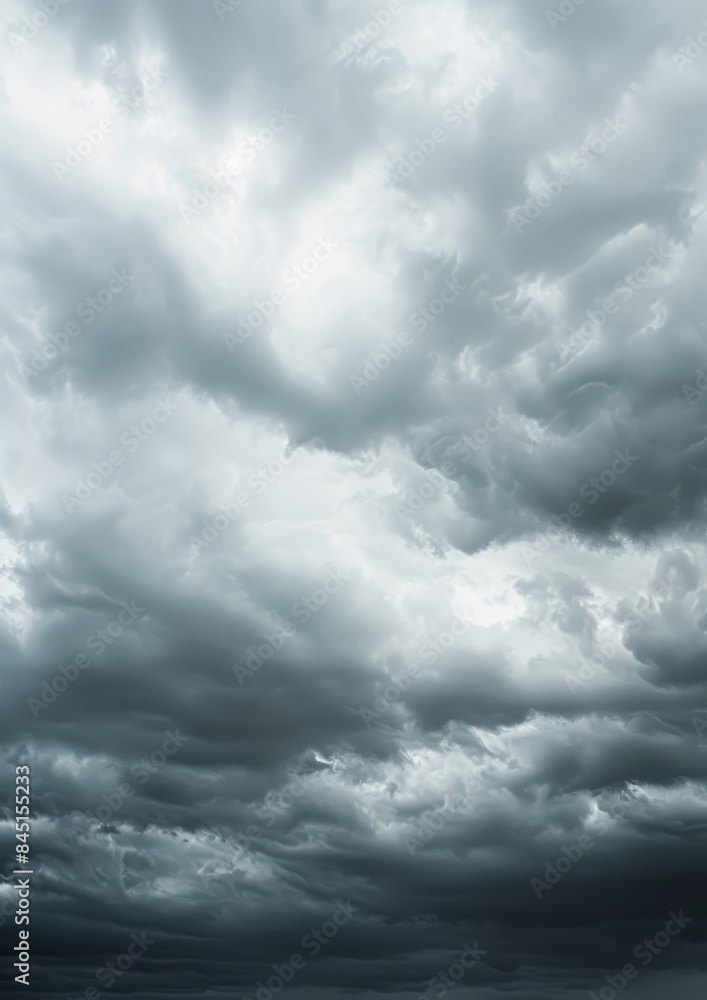 Obraz premium A dramatic cloudscape featuring thick, fluffy storm clouds with soft light filtering through, creating a moody and ethereal atmosphere in the sky.