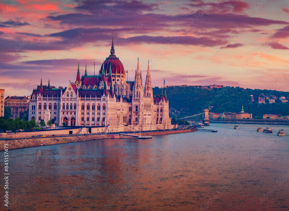 Obraz premium Parliament house on the shore of Dunabe river. Stunning summer cityscape of Budapest. Colorful sunset in Hungary, Europe. Traveling concept background.