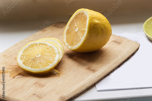 Juicy lemon cut into pieces on a cutting board.
