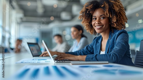 A financial planning session with a group of young professionals discussing investment options with a planner in a white conference room, with laptops and charts on the table. The image features