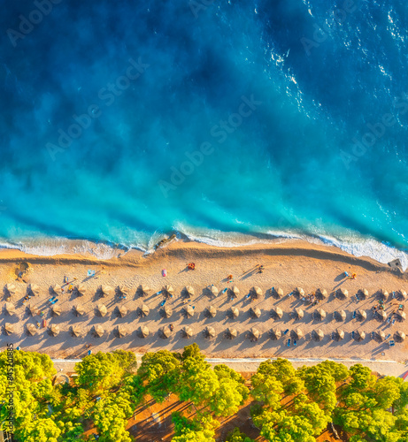 Obraz na płótnie Aerial view on the beach and umbrellas. Vacation and adventure. Beach and blue water. Top view from drone at beach and azure sea. View on the coast from drone. w salonie