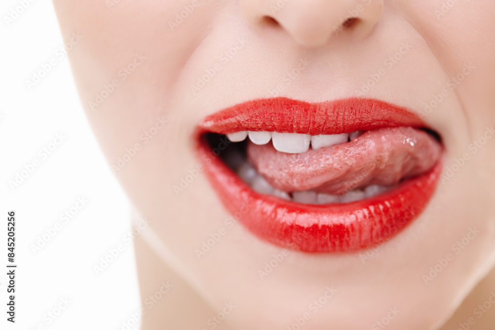 Obraz premium Mouth, woman and tongue out for makeup in studio with red lipstick, cosmetics and teeth. Female model, lips and results or aesthetic by white background for luxury, glow and product or treatment