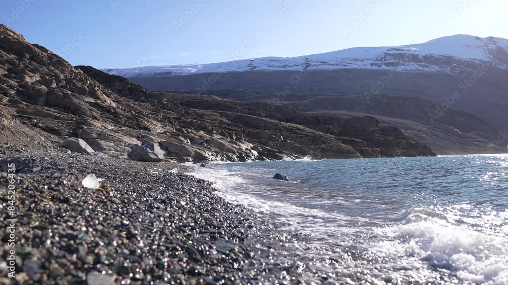 Arctic Sea Waves Breaking on Pebble Beach on Coast on Greenland on Sunny Summer Day, Slow Motion Arctic Sea Waves Breaking on Pebble Beach on Coast on Greenland on Sunny Summer Day, Slow Motion