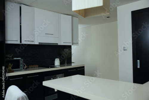 Monochrome kitchen interior with white counter top and black and white sink  minimalist design for modern living space