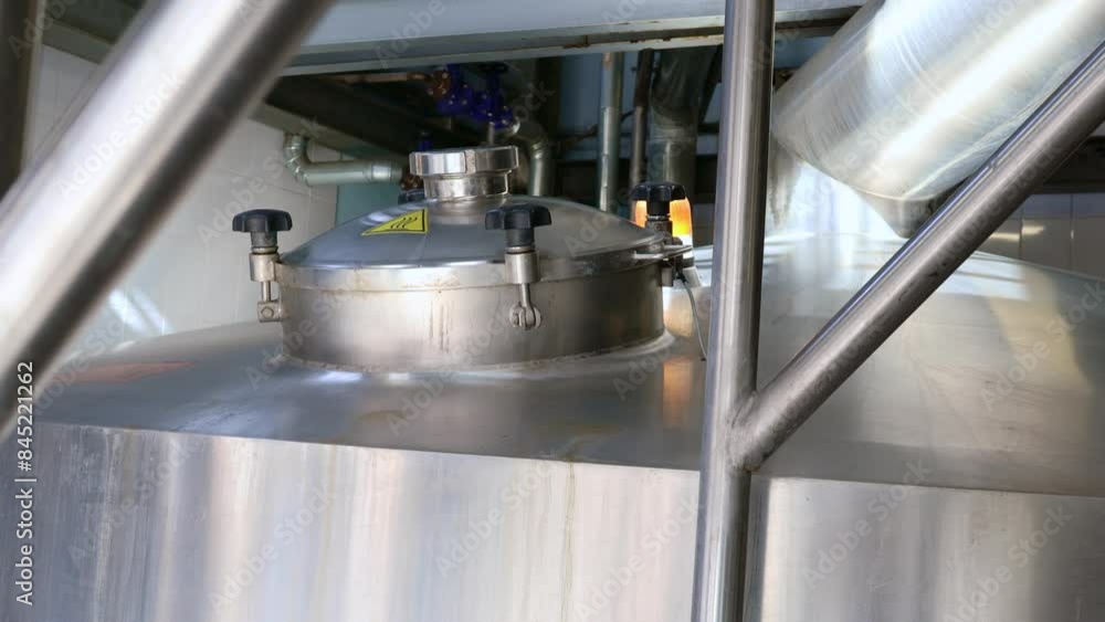 Stainless steel tanks for brewing beer. Huge metal vats in a brewery. Equipment for beer fermentation. Brewing equipment on a factory Stainless steel tanks for brewing beer. Huge metal vats in a brewery. Equipment for beer fermentation. Brewing equipment on a factory