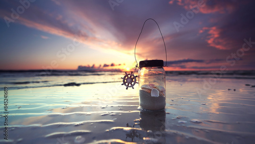 Fototapeta Naklejka Na Ścianę i Meble -  a glass of seashells at the romantic sunset beach