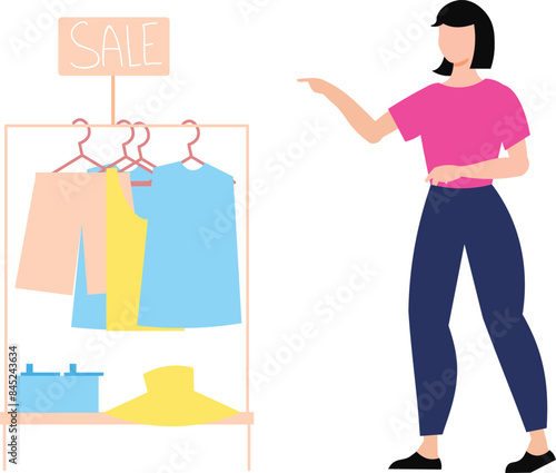 Girl pointing to clothes on rack for sale.
