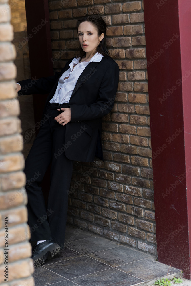 Attractive caucasian young woman in suit posing while walking outdoors on spring day. Luxurious, sexy and elegant lady looking at the camera. Beauty, Fashion, Style, Lifestyle. Attractive caucasian young woman in suit posing while walking outdoors on spring day. Luxurious, sexy and elegant lady looking at the camera. Beauty, Fashion, Style, Lifestyle.