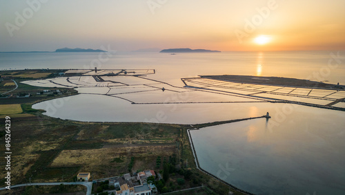 Fotografía aerial view at sunset of trapani sicily salt pond with Aegadian Islands at dista