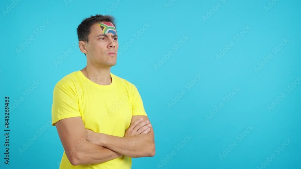 Man with south african flag painted looking away with serious expression Man with south african flag painted looking away with serious expression