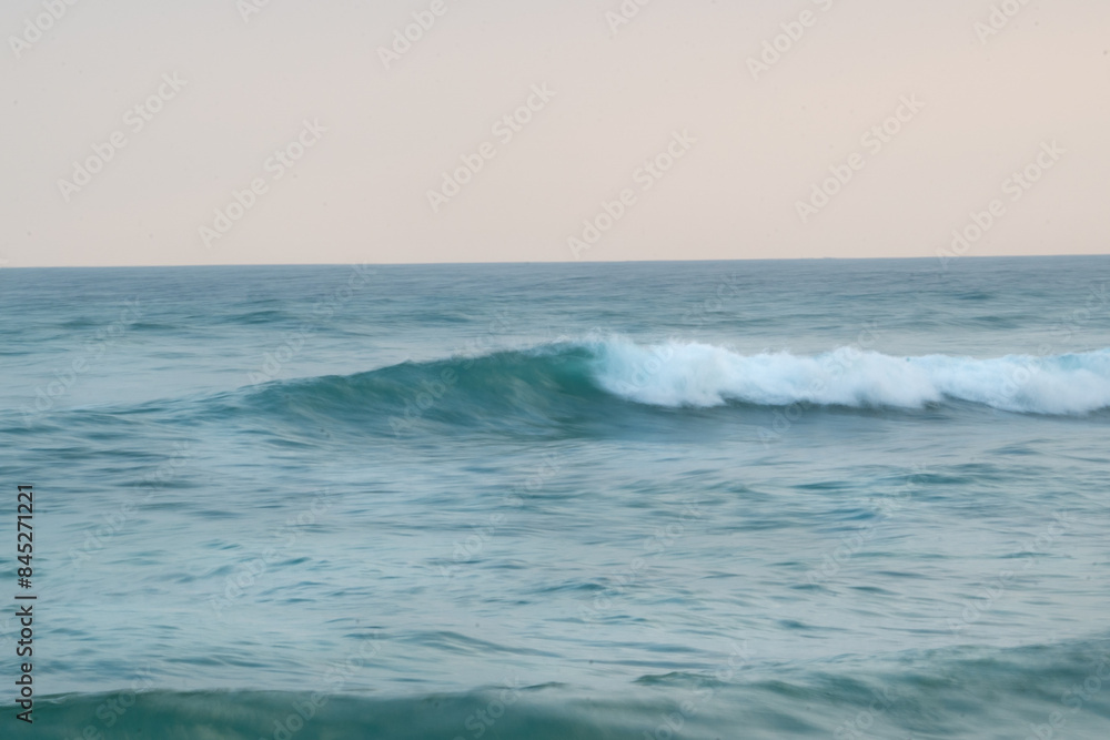 Minimalistic ocean scenery with wave in the evening sun and motion blur Minimalistic ocean scenery with wave in the evening sun and motion blur