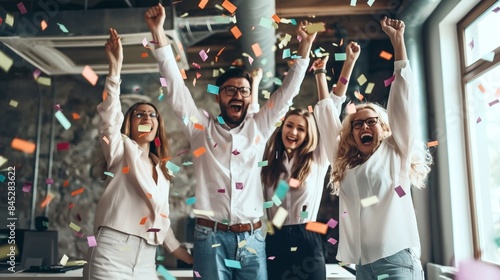 Joyful office workers celebrating with confetti in a lively office environment #845283622