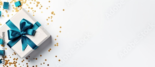 A top view of a gift box with a blue ribbon on a white background offering a discounted gift for sale The image is a flat lay with plenty of copy space conveying a holiday concept