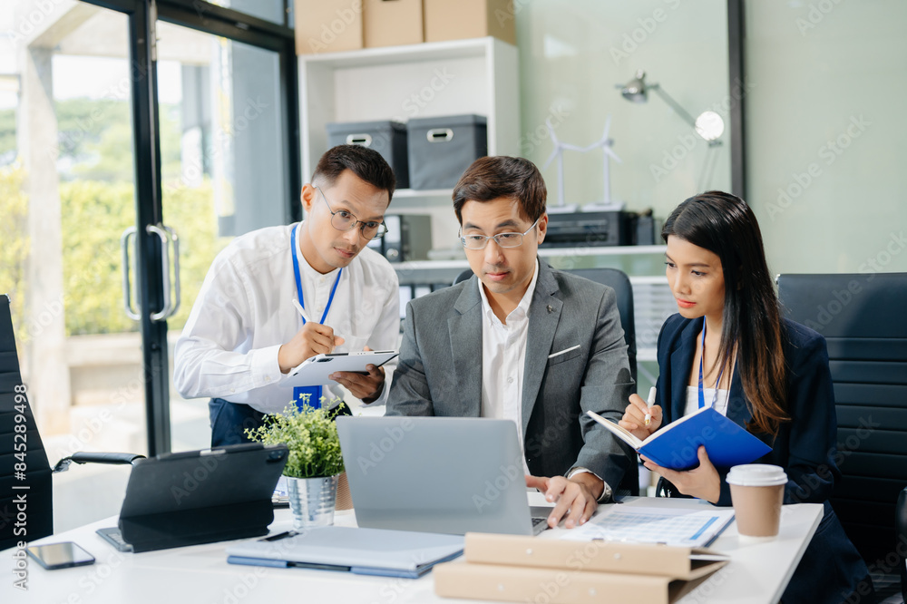 Happy Asian businesspeople while collaborating on a new project. using a laptop and tablet Happy Asian businesspeople while collaborating on a new project. using a laptop and tablet