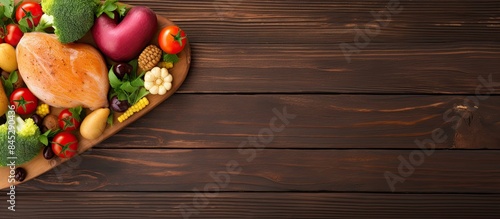 Healthy food concept for Valentine s day and Mother s day with a heart shaped grilled chicken breast steamed vegetables and a wooden table background Top view with copy space image