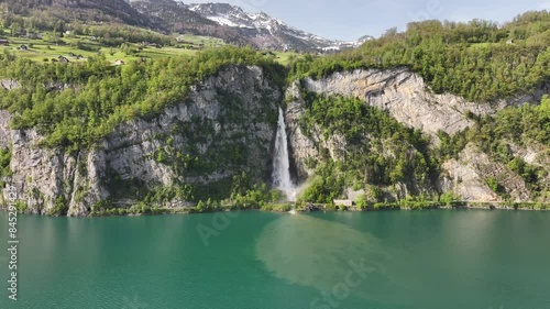 Aerial view of Seerenbach Falls cascading into turquoise Walensee, surrounded by lush cliffs photo