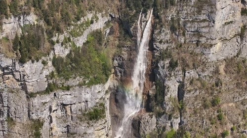 Seerenbach Falls cascading down a rugged cliff face surrounded by greenery in Amden, Betlis, near Walensee, Switzerland photo