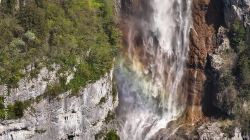 Seerenbach Falls with a vibrant rainbow, cascading down a steep cliff in lush surroundings, Switzerland photo