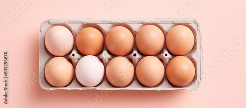 Organic eggs in a carton tray are showcased on a pastel pink background highlighting the zero waste concept The flat lay style creates a visually appealing copy space image
