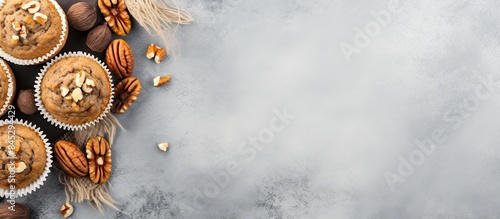 Top view of healthy banana muffins with oatmeal walnuts and cinnamon in baking form on a gray concrete background creating a copy space image photo