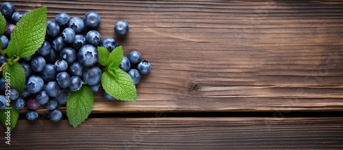 A top view of a fresh and natural blueberry with mint on a wooden table This berry is organic and a good source of vitamins The image provides copy space for text