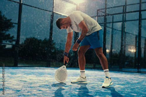 Padel player celebrating after a successful training session in the rain photo