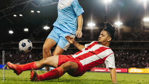 Intense football tackle during professional football match at a full stadium