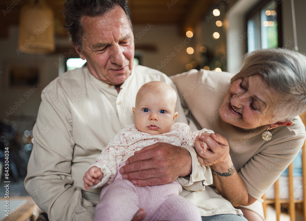 Grandparents holding baby girl, calming her down, soothing her. Strong bond between grandparents and grandchild. Grandparents holding baby girl, calming her down, soothing her. Strong bond between grandparents and grandchild.