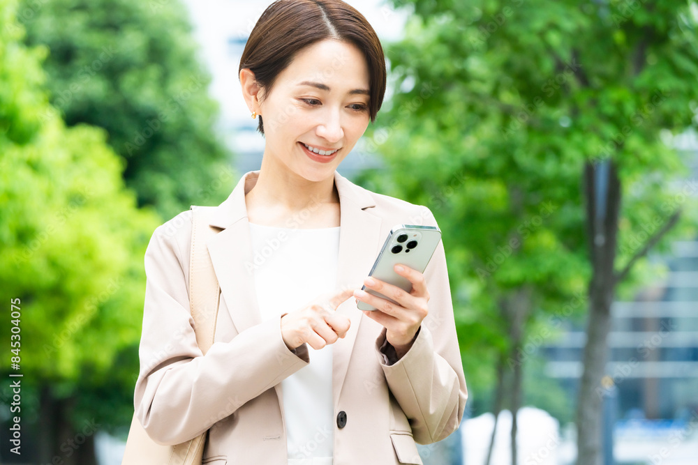 スマートフォンを操作している若い女性　ビジネスイメージ