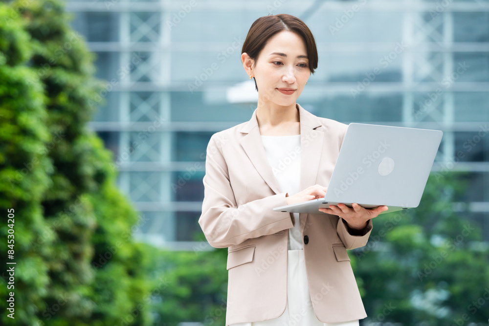 ノートパソコンを操作している若い女性 ビジネスイメージ ノートパソコンを操作している若い女性 ビジネスイメージ