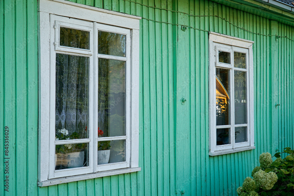 Fototapeta premium Traditional wooden Karaim house painted green - close-up on windows - Trakai, Lithuania