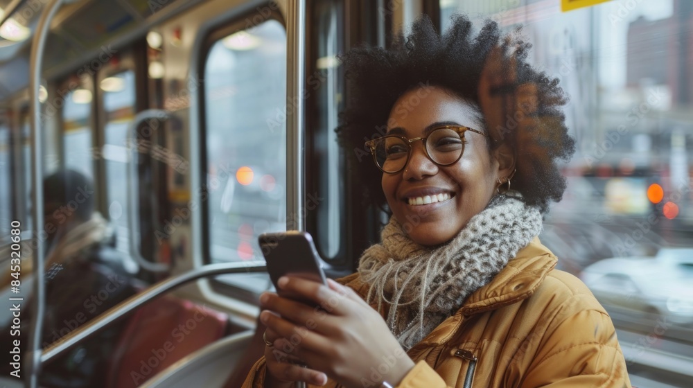 A woman using her cellphone while looking out of a metro train window during her daily commute A woman using her cellphone while looking out of a metro train window during her daily commute