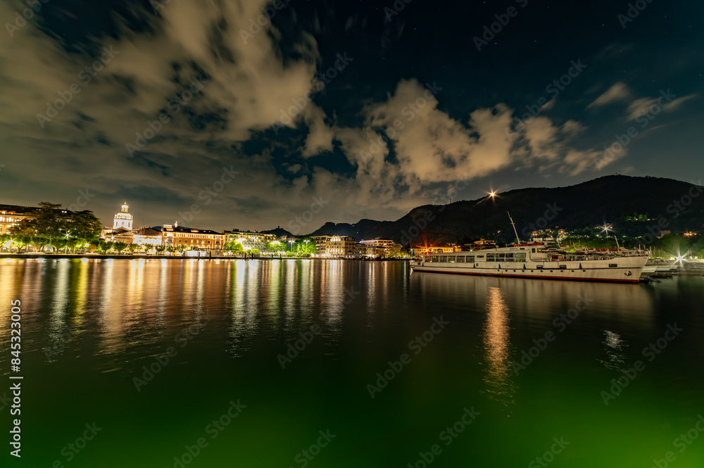 The city of Como, photographed in the evening, with the lakeside, the cathedral, the port and the moored boats. The city of Como, photographed in the evening, with the lakeside, the cathedral, the port and the moored boats.