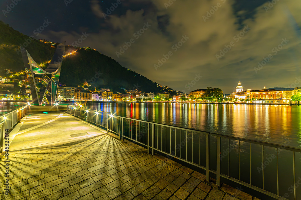 Obraz premium The city of Como, photographed in the evening, with the lakeside, the cathedral, the port and the moored boats.