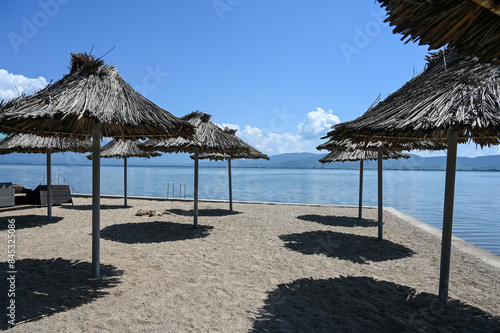 Parasols on sandy beach near water. Exotic beach in summer. Vacation  travel and tourism concept.  