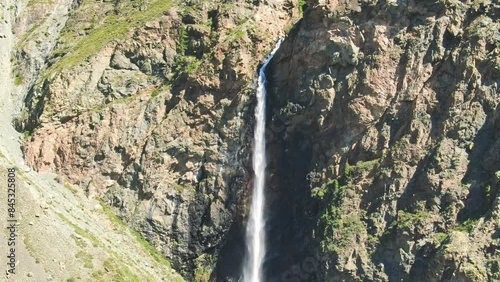 Smooth flight in the mountains above the waterfall. A powerful stream breaks down. Altay.