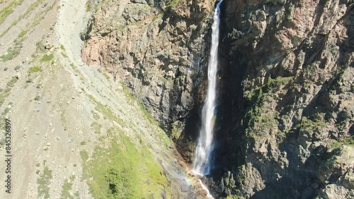 Smooth flight in the mountains above the waterfall. A powerful stream breaks down. Altay.