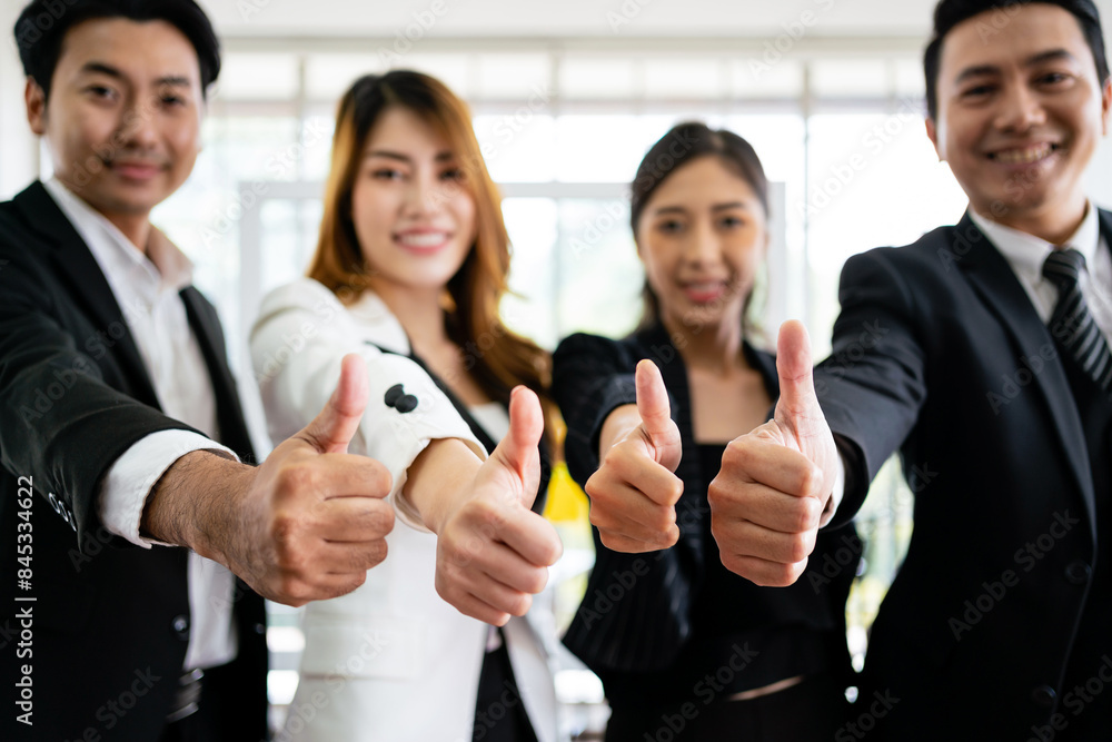 Close up of a group of diverse businesspeople showing raised thumbs at the camera. Recommendation of good choice. The diversity of Asian businesspeople gives a positive response. Close up of a group of diverse businesspeople showing raised thumbs at the camera. Recommendation of good choice. The diversity of Asian businesspeople gives a positive response.