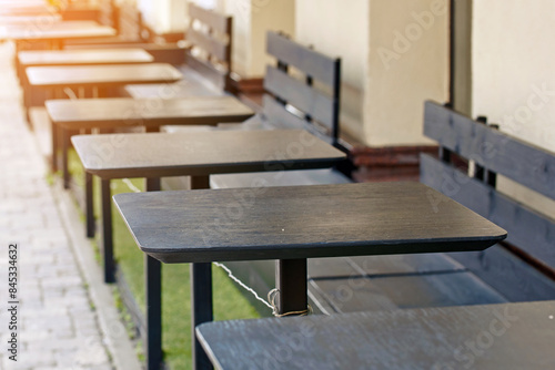 Empty summer terrace with wooden tables and seats  serene and tranquil outdoor dining area.