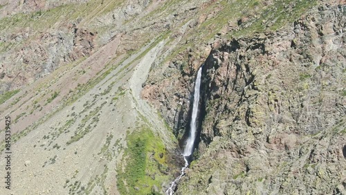 Smooth flight in the mountains above the waterfall. A powerful stream breaks down. Altay.