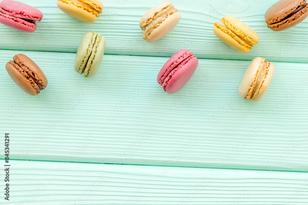 sweet dessert pattern with macarons on mint green wooden background flat lay mockup sweet dessert pattern with macarons on mint green wooden background flat lay mockup