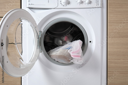 Close-up a sports shoes in a laundry bag in a washing machine with an open drum.