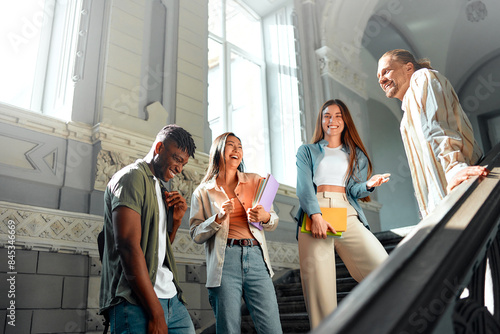 Фотография College students bonding in a historic building stairwell on campus, creating a
