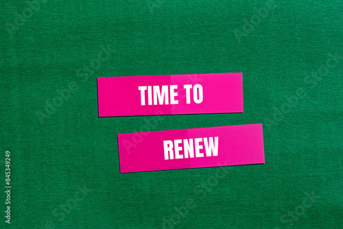 Time to renew message written on pink paper with green background. Conceptual time to renew symbol. Copy space. photo