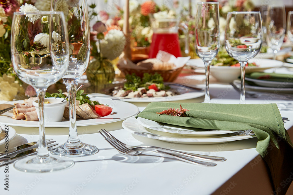 Table setting in elegant chamber is graced by candles and flowers arrangement casting sunlight shadows. The wedding embodies the aesthetics of Provence. Table setting in elegant chamber is graced by candles and flowers arrangement casting sunlight shadows. The wedding embodies the aesthetics of Provence.